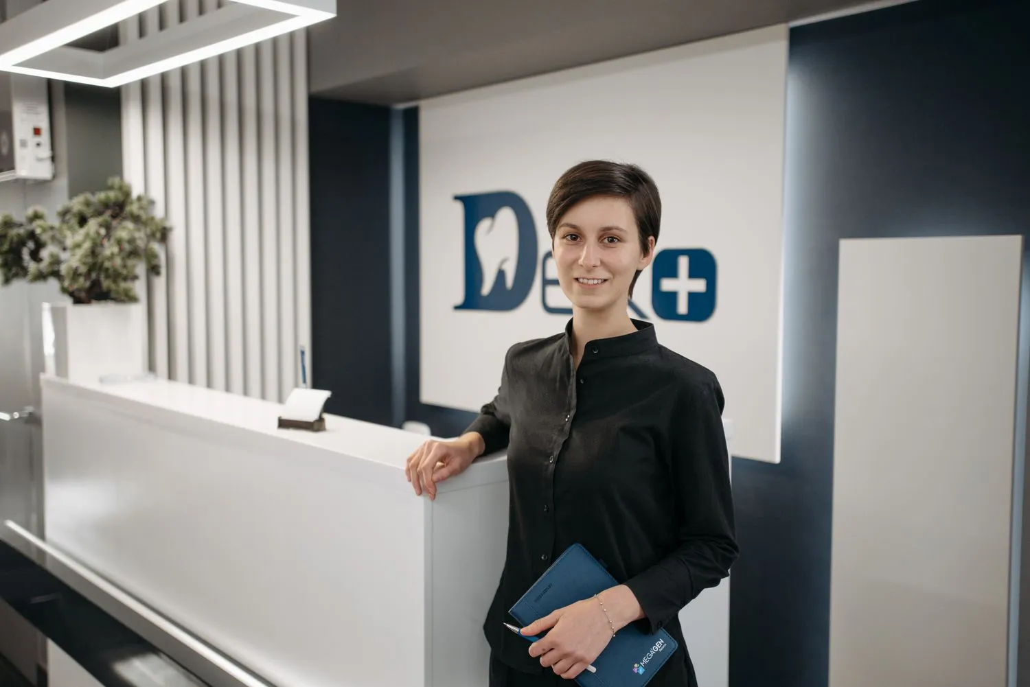 A friendly receptionist at a dental practice front desk
